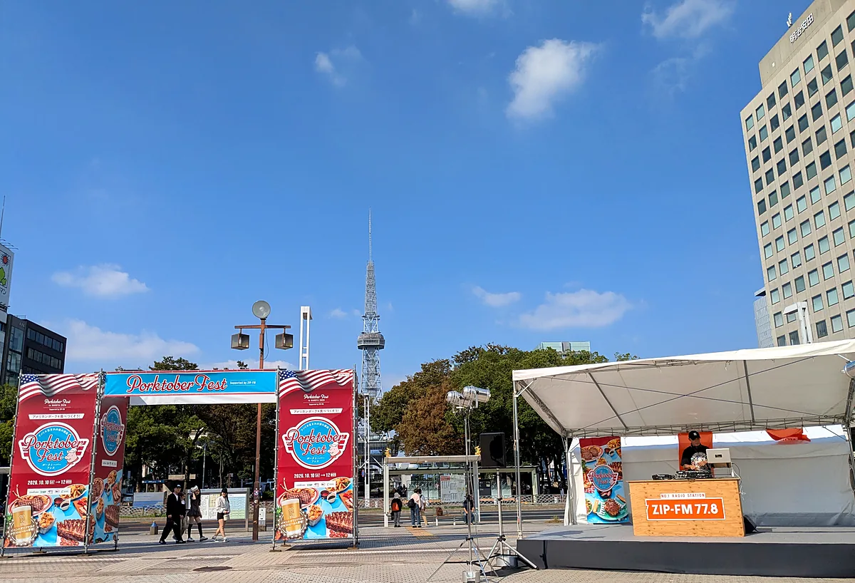 ポークトーバーフェス名古屋2026の会場。入場ゲートの奥に中部電力 MIRAI TOWER、右手にZIP-FMのステージ