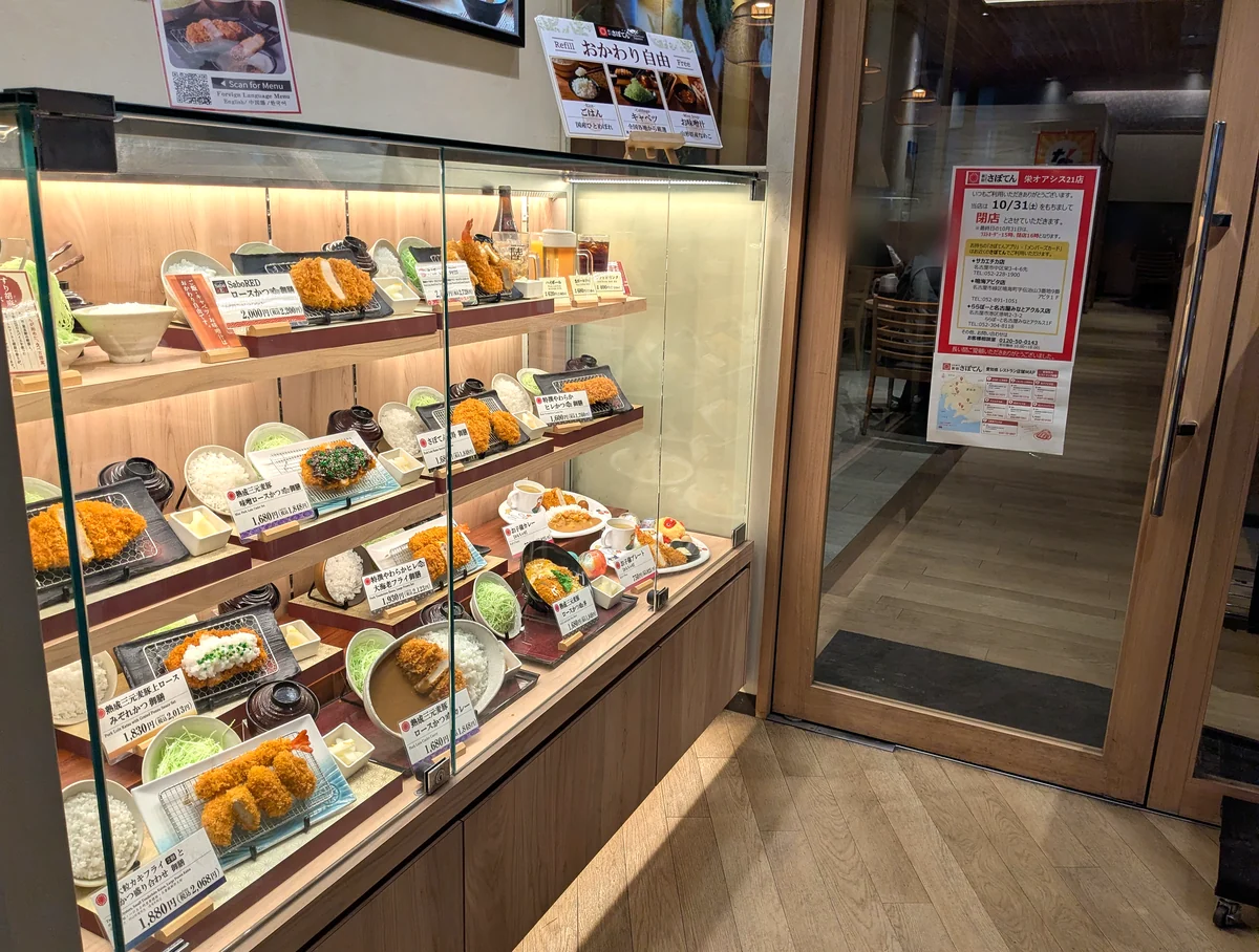 栄オアシス21店の食品サンプルのショーケース。上に「おかわり自由」の案内、右の扉に閉店のお知らせが貼られている