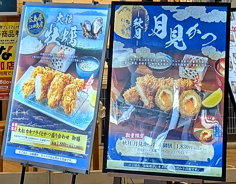 店頭に並ぶ期間限定メニューの看板。広島県江田島産の大粒カキフライの御膳と、数量限定の秋月 月見かつ彩り御膳