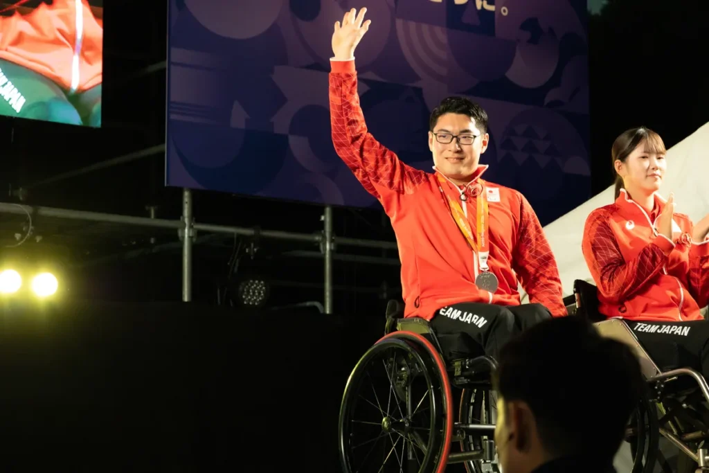 アスリートセレブレーションのステージで手を挙げるパラ卓球の七野一輝選手