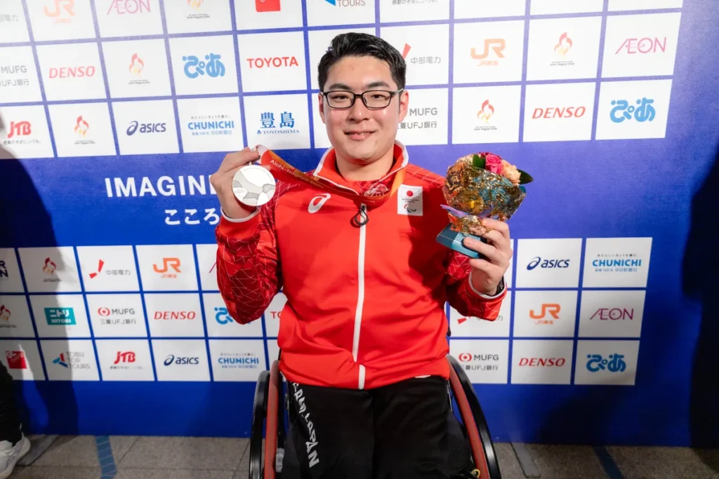 ミックスゾーンで銀メダルと花束を手にするパラ卓球の七野一輝選手