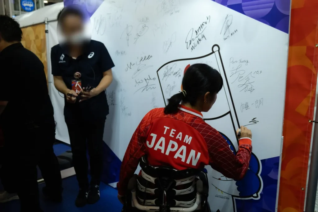 ライブサイトのサインウォールにサインを書き込む選手