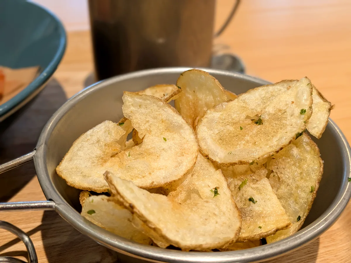 スノーピークカフェの手作りポテトチップス(のり塩)。厚めにスライスしたジャガイモをステンレスのボウルに盛り付け