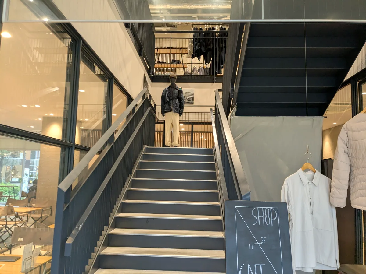 スノーピーク久屋大通公園の2階ショップへ上がる階段と「SHOP 2F・CAFE 1F」の黒板