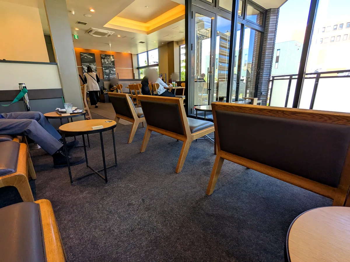 スターバックス御器所駅前店の2階客席。カーペット敷きに木枠のベンチソファと丸テーブルが並ぶ