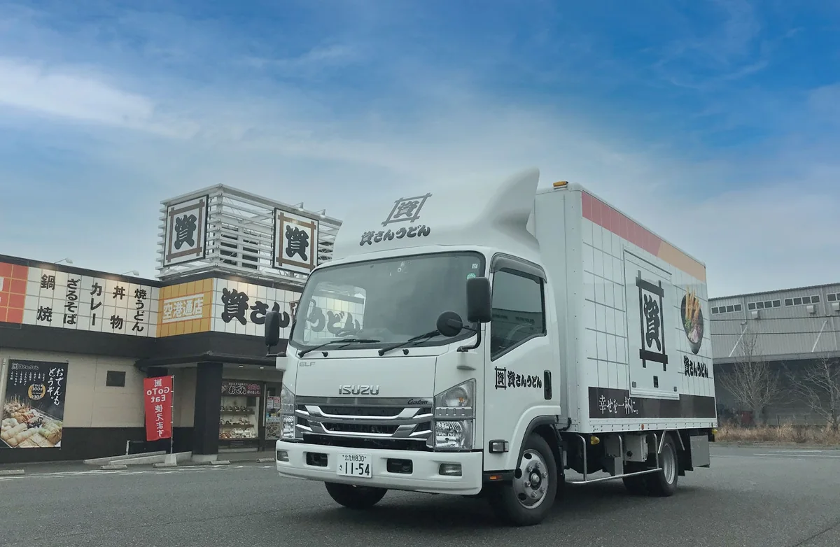 資さんうどんのキッチンカー。白いトラックの側面に「資」のロゴが入っている
