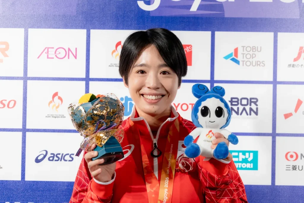 ウズミンのぬいぐるみと花束を手に笑顔を見せる髙桑早生選手