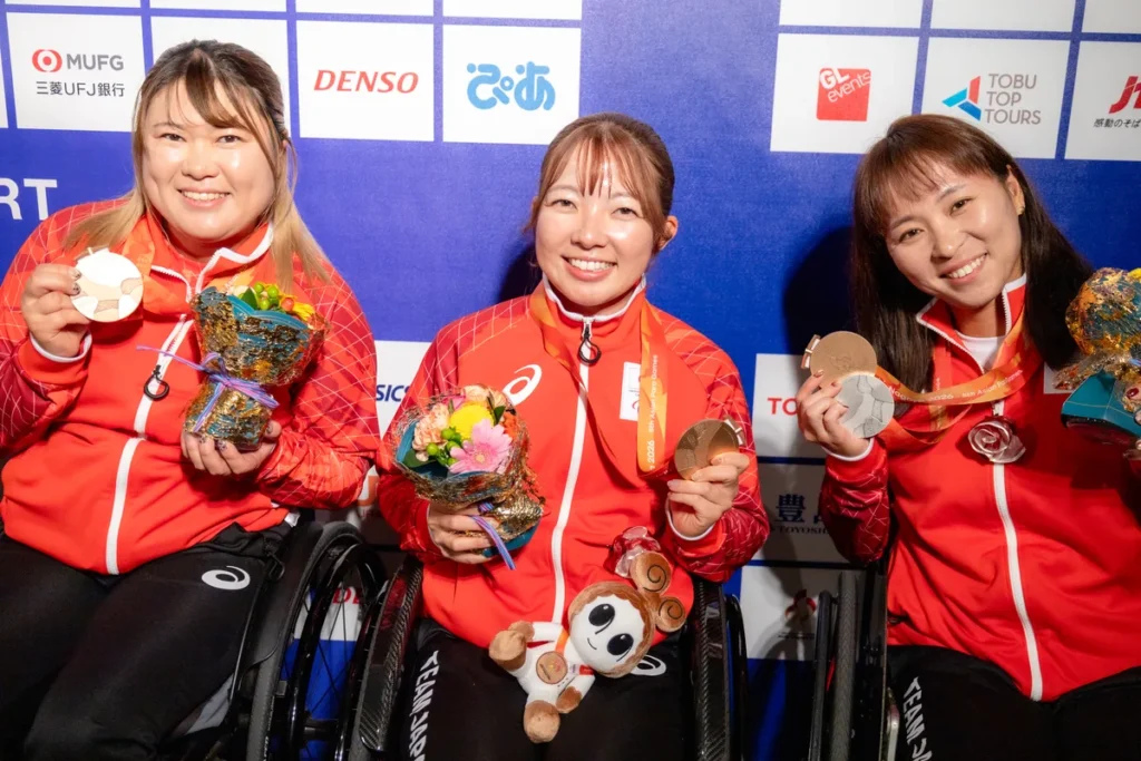 ミックスゾーンでメダルと花束を手に並ぶ車いすテニスの髙室冴綺選手、田中愛美選手、大谷桃子選手