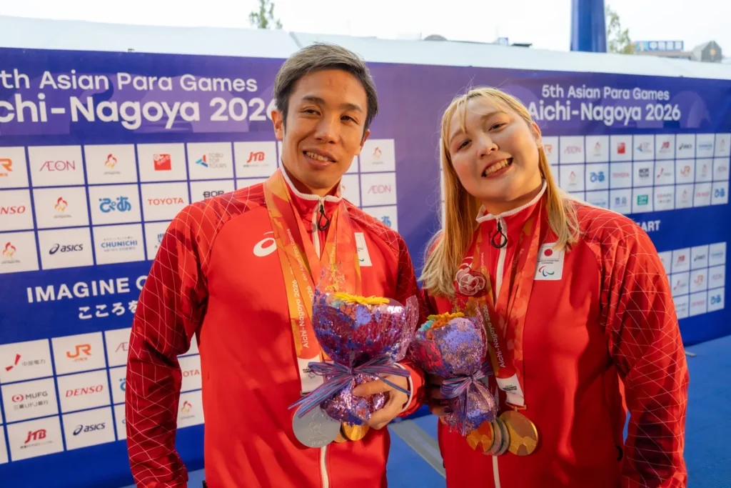 メダルと花束を手にする富田宇宙選手と辻内彩野選手
