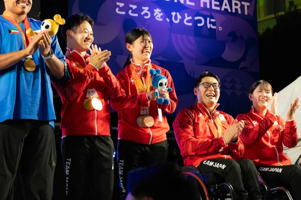 アスリートセレブレーションのステージで拍手を送るパラ卓球の友野有理選手。銀と銅のメダルを首にかけている
