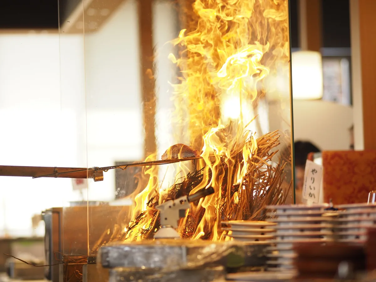 魚魚丸の店内特設ブースで藁の炎が燃え上がる藁焼きショー