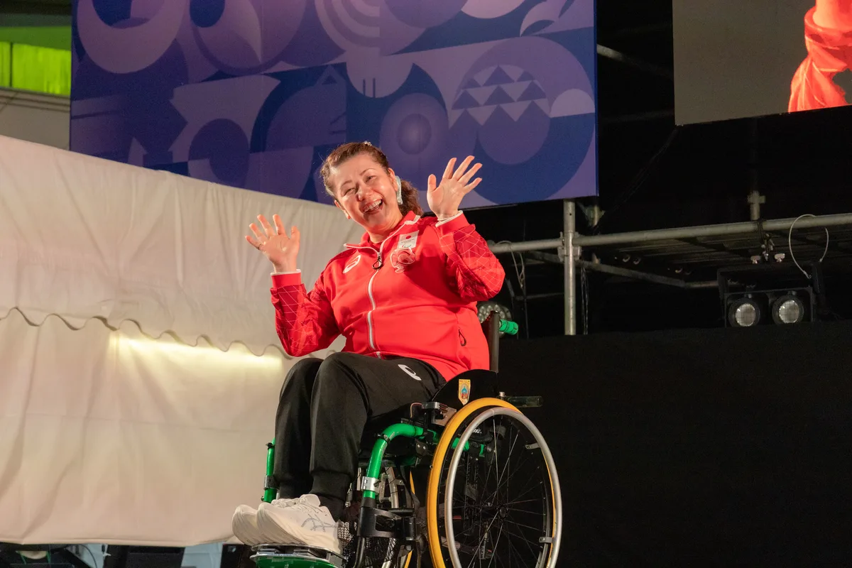 車いすでステージに登場し手を振る辻尾玲奈選手
