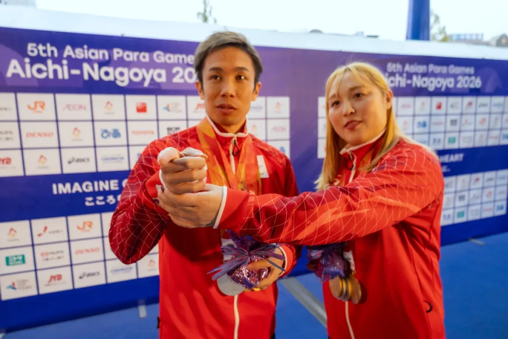 富田宇宙選手の腕に手を添えて、カメラの方向を伝える辻内彩野選手