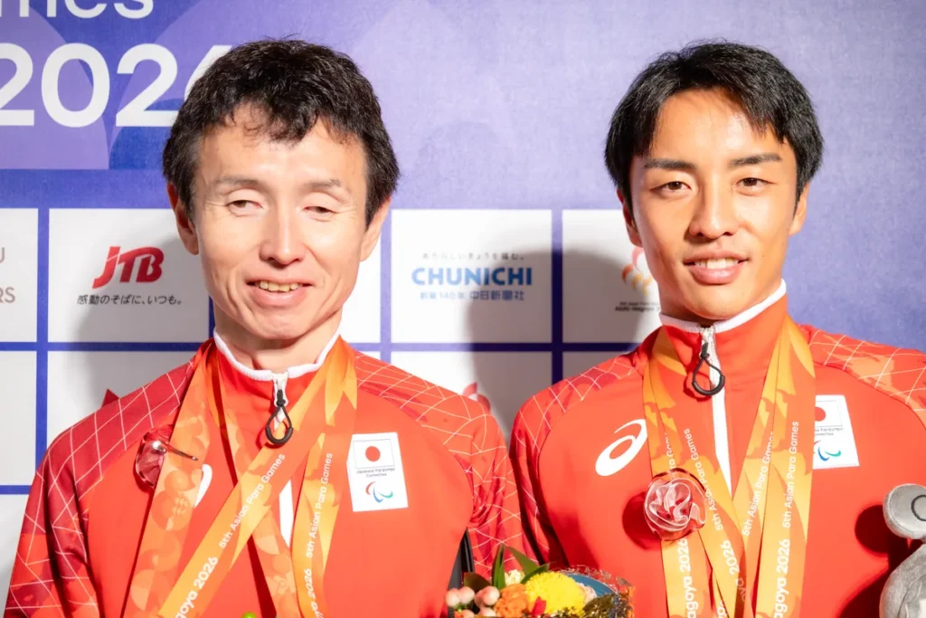 銀メダルを掛けて笑顔を見せる和田伸也選手(左)と長谷部匠さん