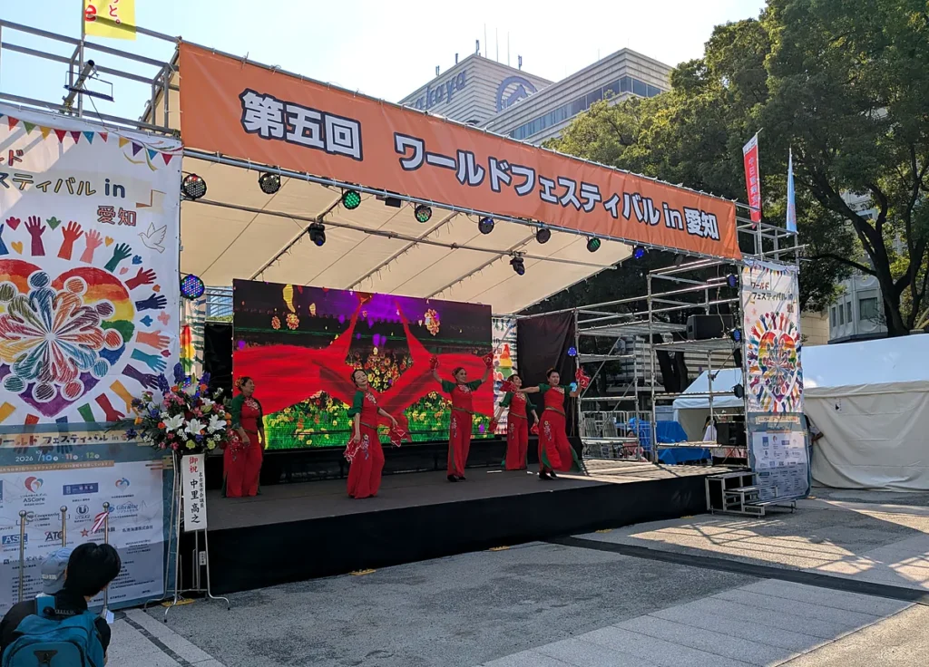 第5回ワールドフェスティバルin愛知のステージで、赤い衣装で踊る出演者たち（久屋大通公園エンゼル広場）