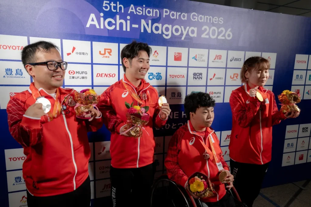 メダルと花束を掲げるパラ卓球の八木克勝選手、舟山真弘選手、北川雄一朗選手、山口美也選手