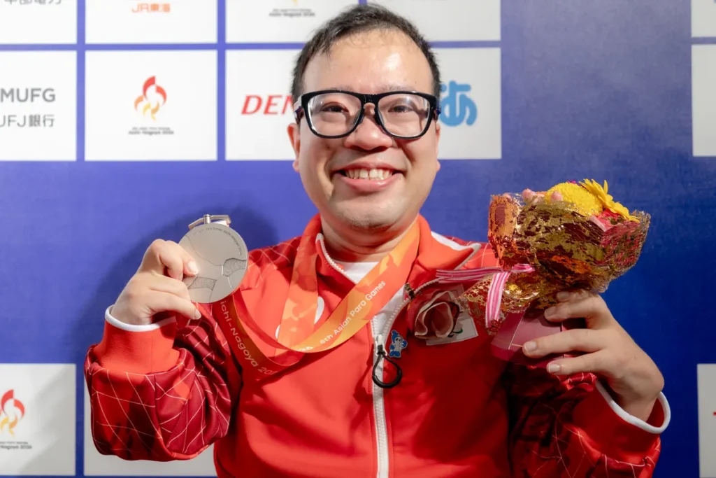 銀メダルと花束を手に笑顔を見せるパラ卓球の八木克勝選手