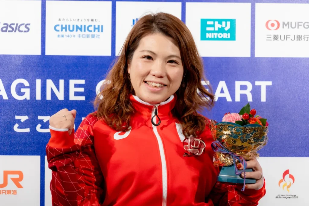 花束を手にガッツポーズで笑顔を見せる山本恵理選手