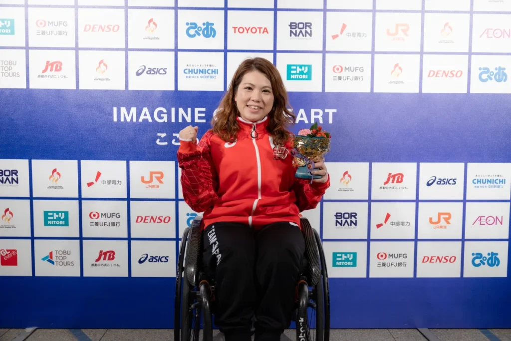 ミックスゾーンで花束を手にする車いすの山本恵理選手